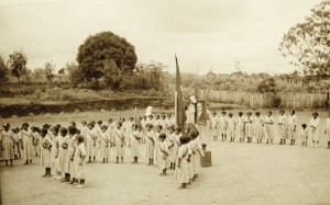 Cerimônia cívicoreligiosa na missão de Iauretê, reunindo um grupo de crianças tucanas e tendo ao fundo o retrato do então presidente Getúlio Vargas