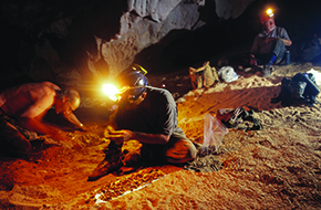 El fotógrafo Adriano Gambarini retrató a Cartelle (a la izq.) y a sus dos colaboradores durante la extracción de los fósiles en 1992 en Toca da Boa Vista. Al lado, una de las amplias cavidades de la caverna