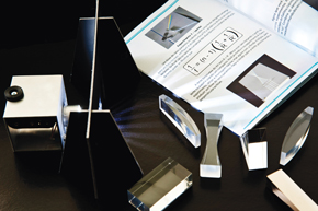 The optics kit relies on prisms and mirrors to demonstrate basic concepts in physics, like the reflection of light